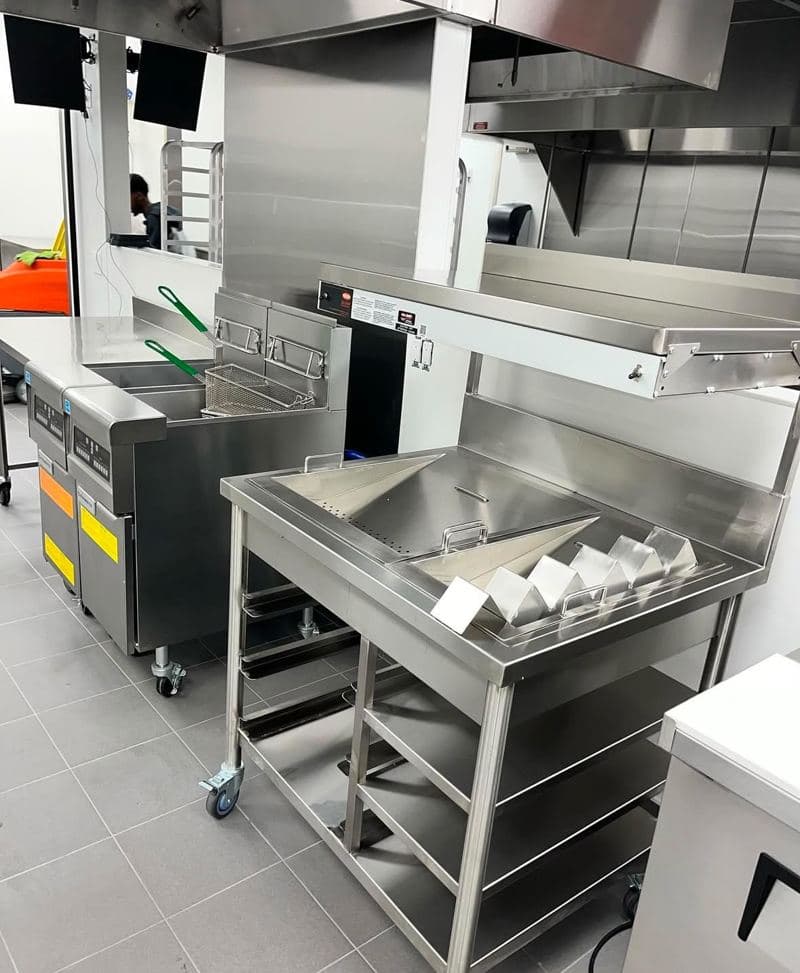Stainless steel prep tables and sinks in a commercial kitchen