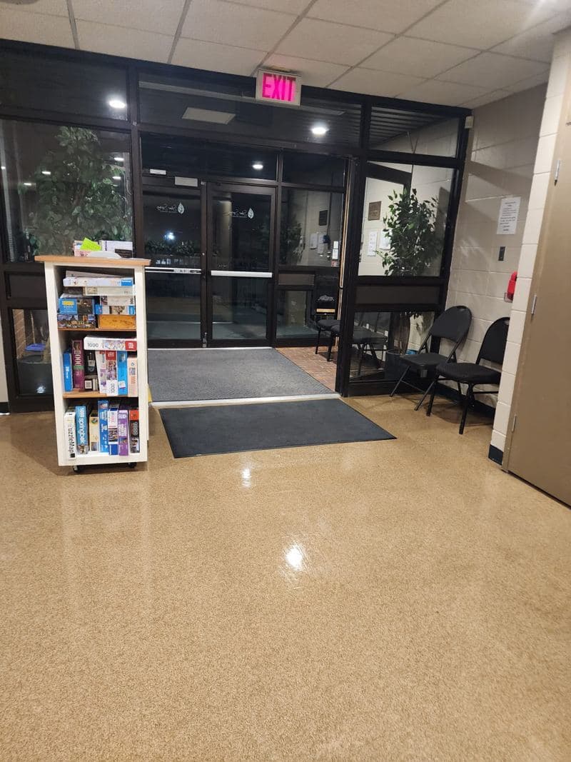 Building entrance with clean glass doors, entrance matting and a polished floor