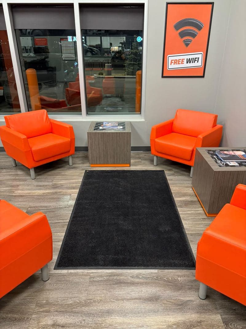 Showroom customer lounge with orange armchairs and a clean entrance mat