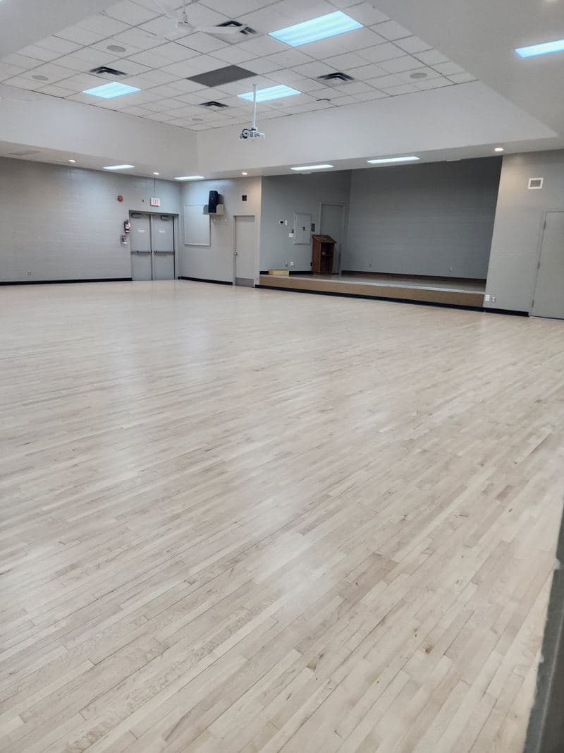 Empty event hall with a freshly cleaned light wood floor