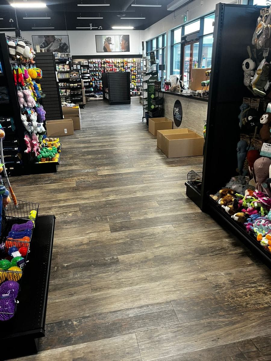 Retail aisle with a cleaned wood-effect floor between stocked shelves